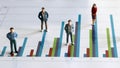 Business concept with miniature people standing on a graph. Royalty Free Stock Photo